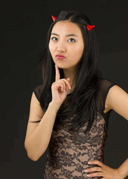 亚洲的年轻女人打扮成魔鬼站在一起在臀部上的手 — 图库照片