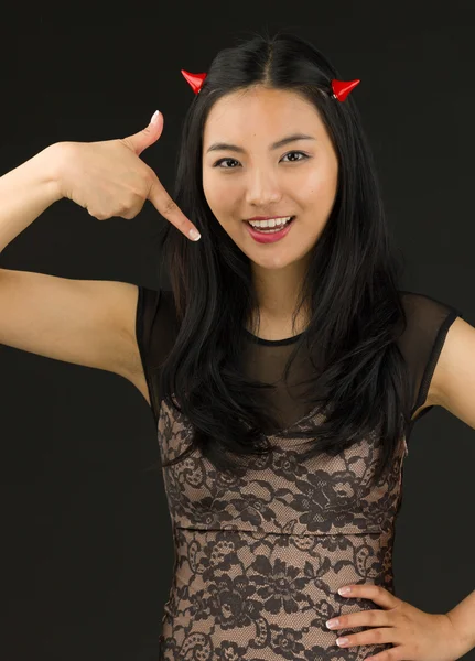 Азиатская девушка в костюме дьявола, указывающая на себя — стоковое фото