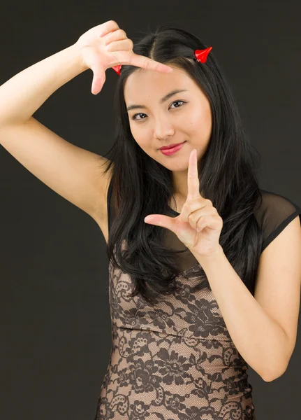 Asian young woman dressed up as an devil making frame with fingers — Stock Photo, Image