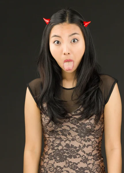 Asian young woman dressed up as an devil sticking out her tongue — Stock Photo, Image