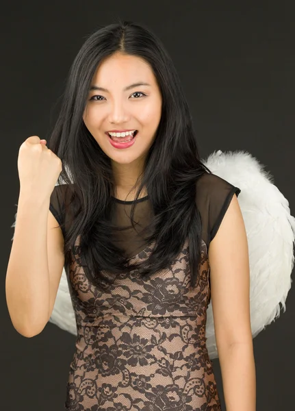 亚洲的年轻女子打扮成一个天使，用拳头庆祝她的成功 — 图库照片