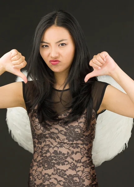 Asiática joven mujer vestida como un ángel mostrando pulgares abajo signo de ambas manos —  Fotos de Stock