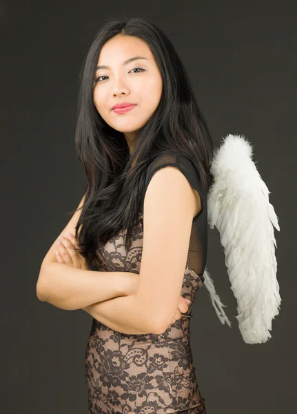 一位身穿天使装且双臂交叉的亚洲年轻女子的侧貌 — 图库照片