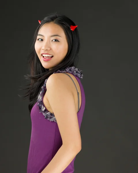 Devil side of a young Asian woman smiling — Stock Photo, Image