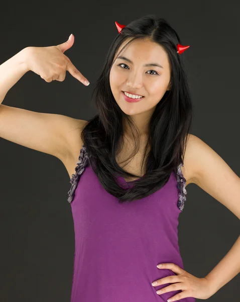 Devil side of a young Asian woman pointing herself and smiling — Stock Photo, Image