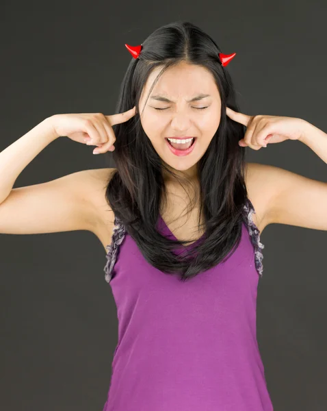 Diabo lado de uma jovem mulher asiática gritando em frustração com os dedos nas orelhas — Fotografia de Stock