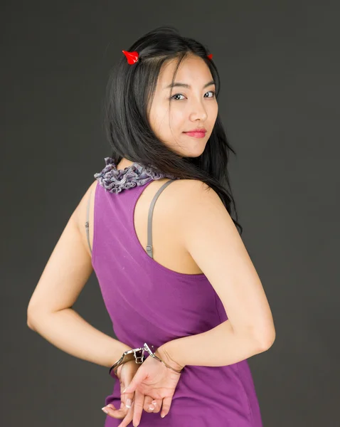 Ďábel strana mladé asijské ženy s pouty a usmívá se — Stock fotografie