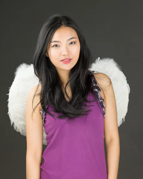 Genç Asyalı bir kadının melek tarafı ayakta ve gülümsüyor. — Stok fotoğraf