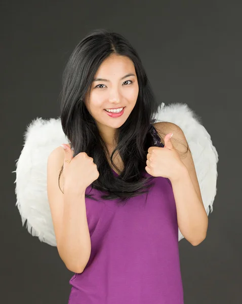 Angel side of a young Asian woman showing thumbs up sign with both hands and smiling — Stock Photo, Image
