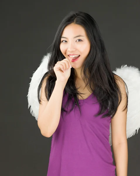 Engelseite einer jungen asiatischen Frau, die ihre Nägel beißt und lächelt — Stockfoto