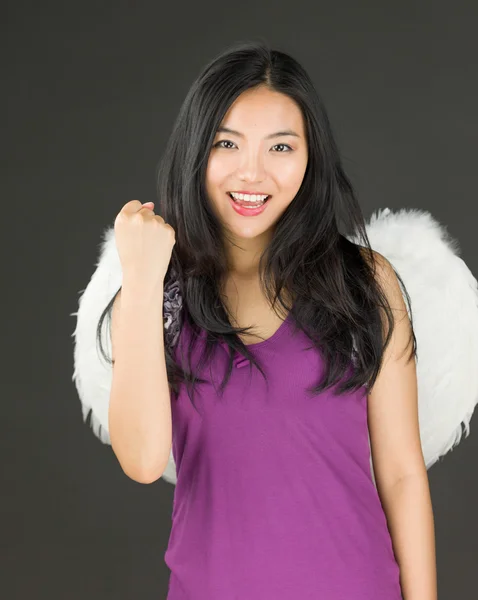 Ангельская сторона молодой азиатки, празднующей успех с поднятым кулаком — стоковое фото