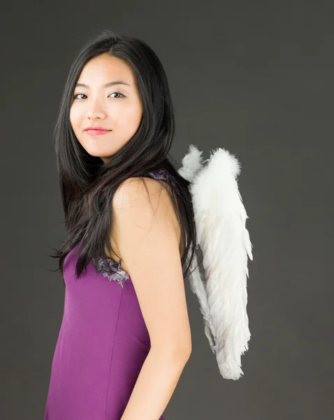 Côté ange d'une jeune femme asiatique debout et souriante — Photo