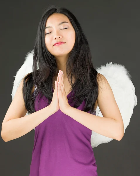 Angel kant van een jonge Aziatische vrouw permanent in gebed standpunt — Stockfoto