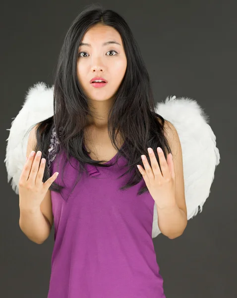 Devil side of a young Asian woman gesturing with hands and looking shocked — Stock Photo, Image