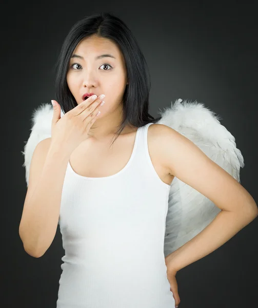 Shocked Asian young woman dressed up as an angel with hand on hip — Stock Photo, Image