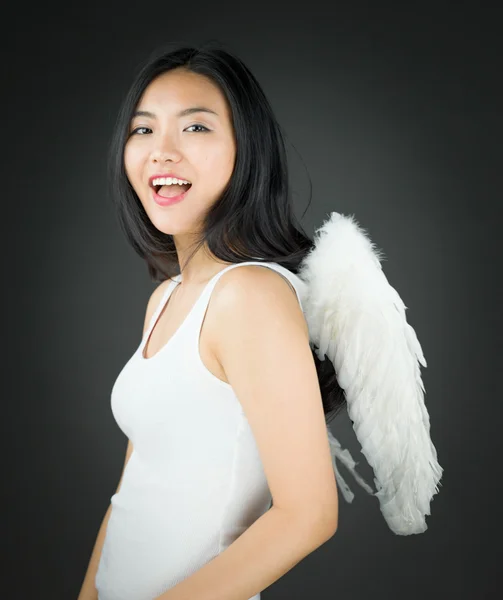 Side view of a Asian young woman dressed up as an angel smiling — Stock Photo, Image