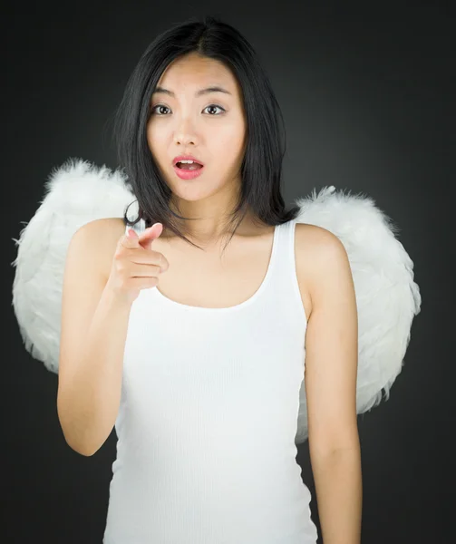 Shocked Asian young woman dressed up as an angel showing something — Stock Photo, Image
