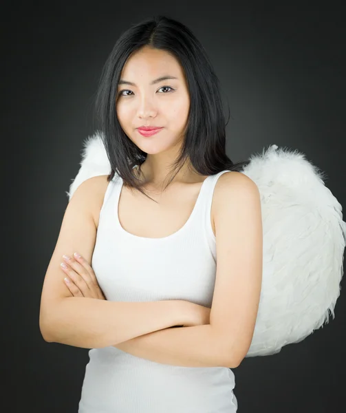 Confident Asian young woman dressed up as an angel with her arms crossed — Stock Photo, Image