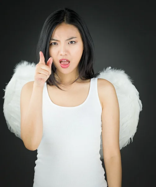 Enojada joven asiática vestida como un ángel regañando a alguien — Foto de Stock