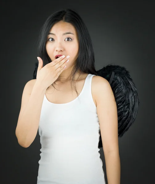 Chockad asiatiska ung kvinna utklädd som en ängel med handen över munnen — Stockfoto