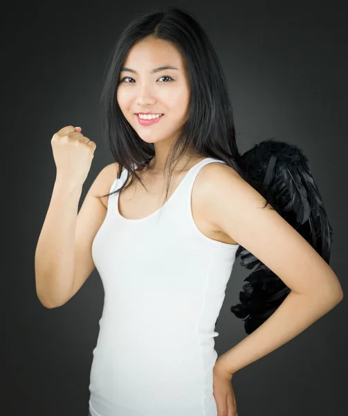 Asiática joven mujer vestida como un ángel celebrando su éxito con su mano en la cadera — Foto de Stock