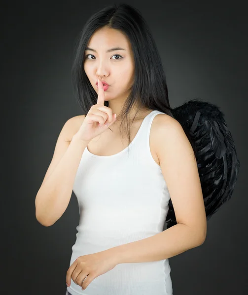 Asiática jovem mulher vestida como um anjo com o dedo nos lábios pedindo silêncio — Fotografia de Stock