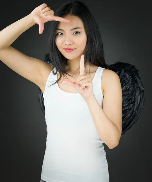 Asian young woman dressed up as an angel making frame with fingers — Stock Photo, Image