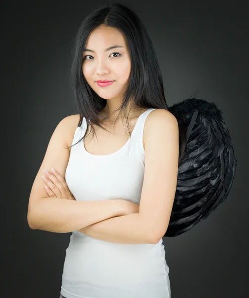 Уверенная азиатская молодая женщина, одетая как ангел со скрещенными руками — стоковое фото