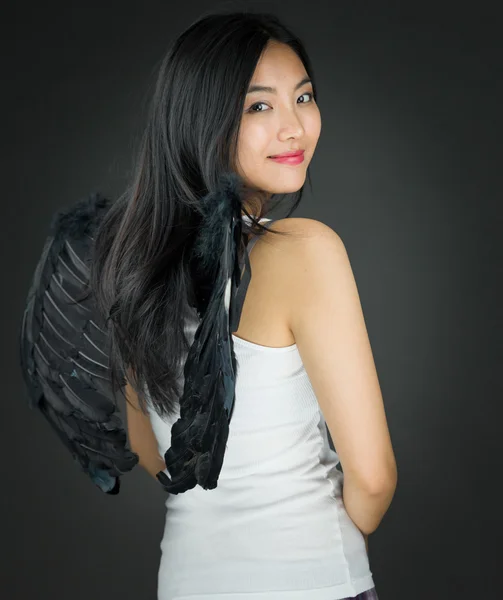 Rückansicht einer asiatischen jungen Frau, die sich als Engel verkleidet umdreht — Stockfoto