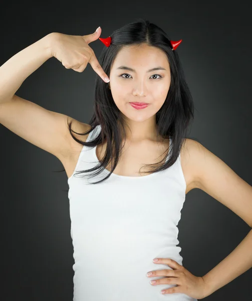 Asian young woman in devil horns and pointing herself with hand on hip — Stock Photo, Image