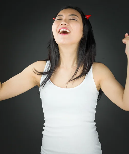 Asiática joven mujer en el diablo cuernos celebrando su éxito — Foto de Stock