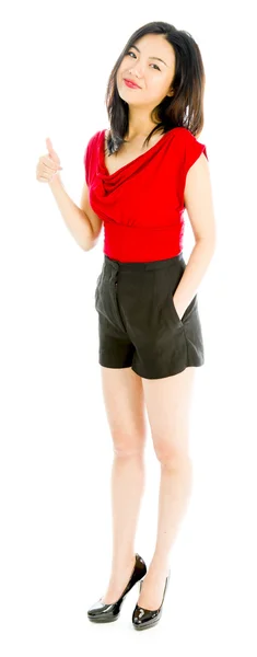 Young woman standing and showing thumbs up sign — Stock Photo, Image