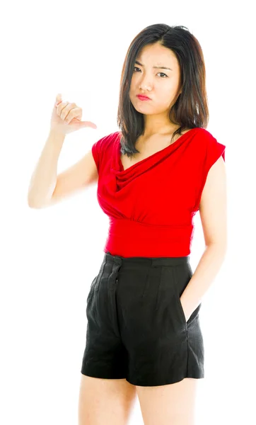 Young woman standing and showing thumbs down sign — Stock Photo, Image