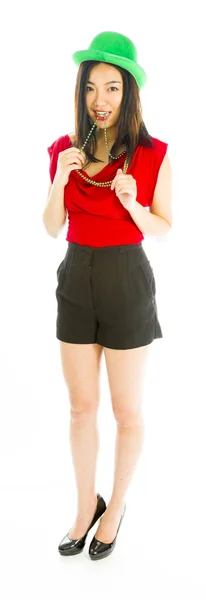 Young woman standing with necklace in her mouth — Stock Photo, Image