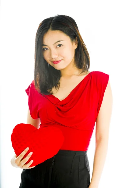 Retrato de uma jovem mulher segurando almofada em forma de coração — Fotografia de Stock
