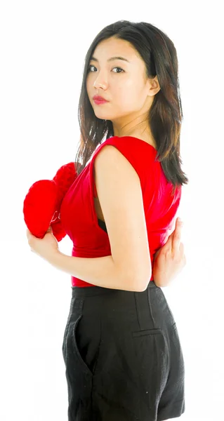 Kalp şekli yastık holding ve isteyen genç bir kadın portresi — Stok fotoğraf