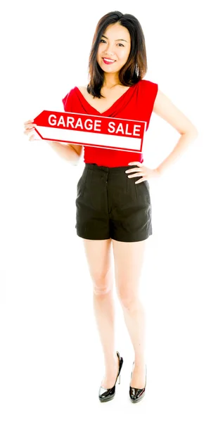 Продавщица с табличкой "Продажа в гараже" и улыбкой — стоковое фото