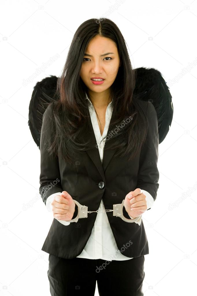 Sad Asian young businesswoman dressed up as black angel handcuffs isolated on white background