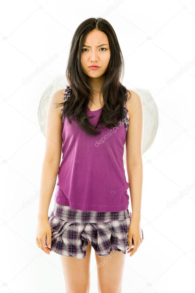 Serious Asian young woman dressed up as an angel isolated on white background