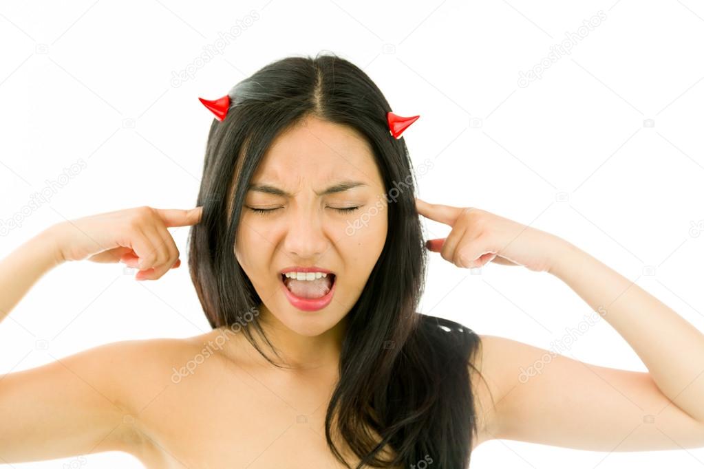 Devil side of a young naked Asian woman shouting in frustration with fingers in ears