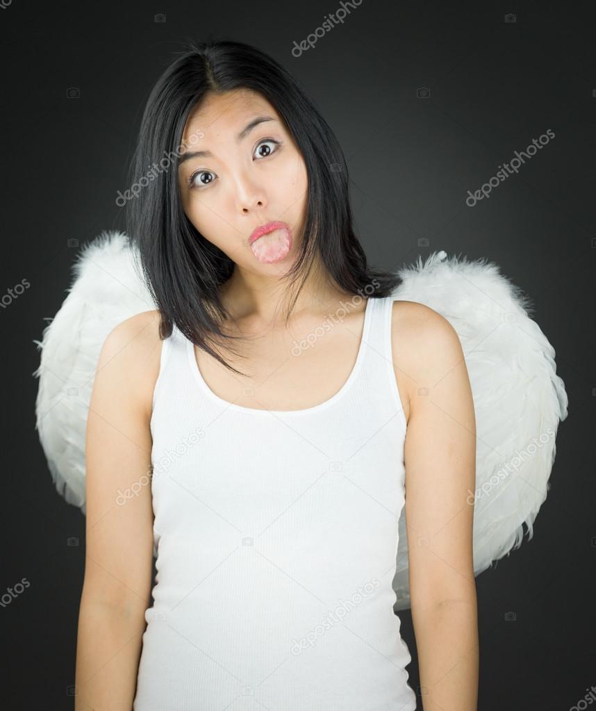 Asian young woman dressed up as an angel sticking out her tongue