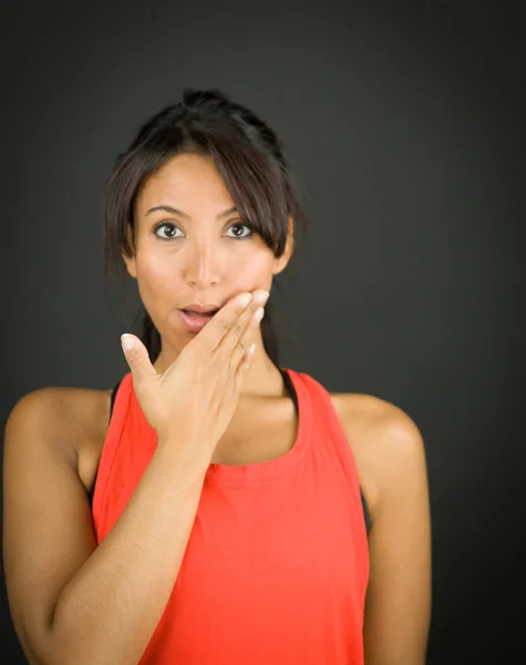 Porträtt av en ung kvinna ser chockad med händerna över mun — Stockfoto