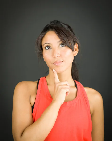 Mujer joven pensativa mirando hacia arriba con el dedo en la barbilla —  Fotos de Stock