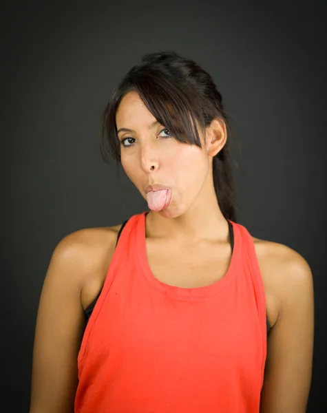 Retrato de una joven mujer sobresaliendo de su lengua — Foto de Stock