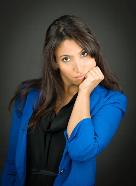 Portrait of a bored young businesswoman with hand on chin — Stock Photo, Image