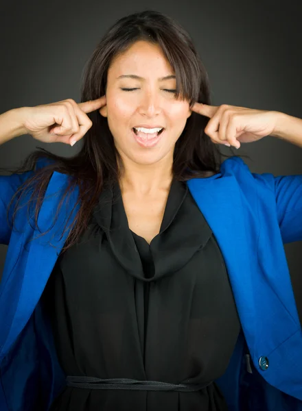 Frustrierte junge Geschäftsfrau schreit mit den Fingern in den Ohren — Stockfoto