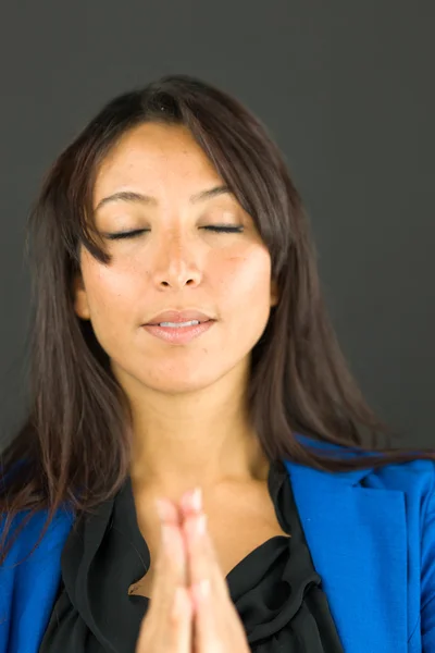 Close up of a young businesswoman in prayer position with her hands clasped — Stock Photo, Image