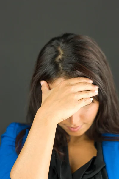 Jonge zakenvrouw met haar hoofd in handen van streek — Stockfoto