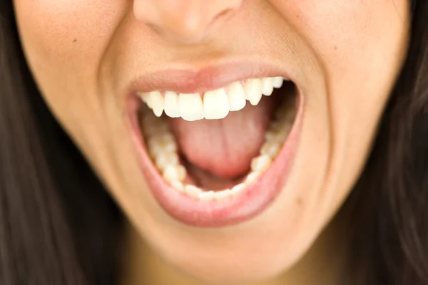 Экстремальный крупный план молодой женщины, кричащей с открытым ртом — стоковое фото