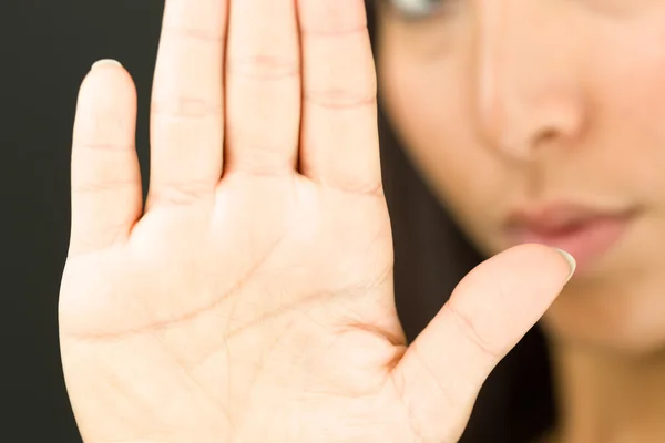 Extreme close-up of a young  woman making stop gesture sign with her hand — Stock Photo, Image